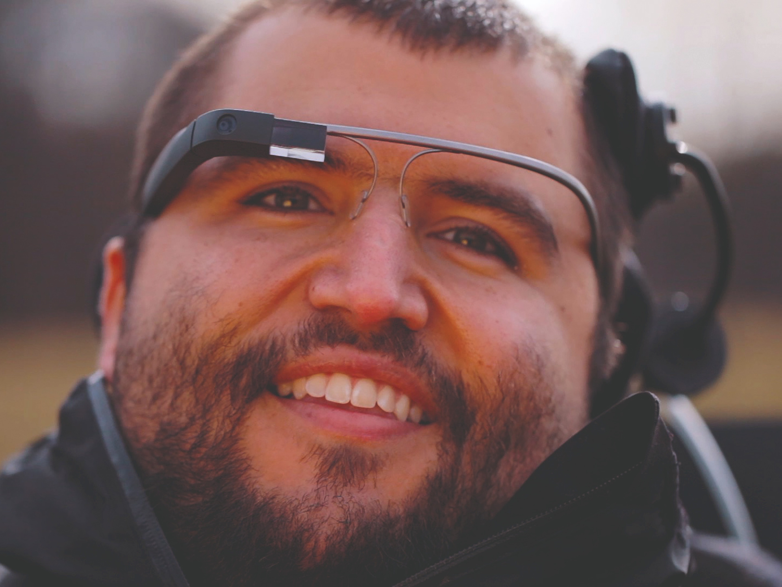 Glücklicher Mann mit Brille zur Rollstuhlsteuerung