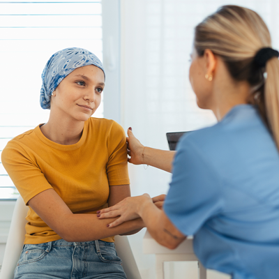 Frau hält Hand von krebskranker Frau